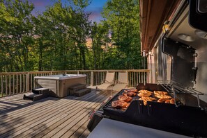 En terrasse med grill, jacuzzi og udendørs møbler.