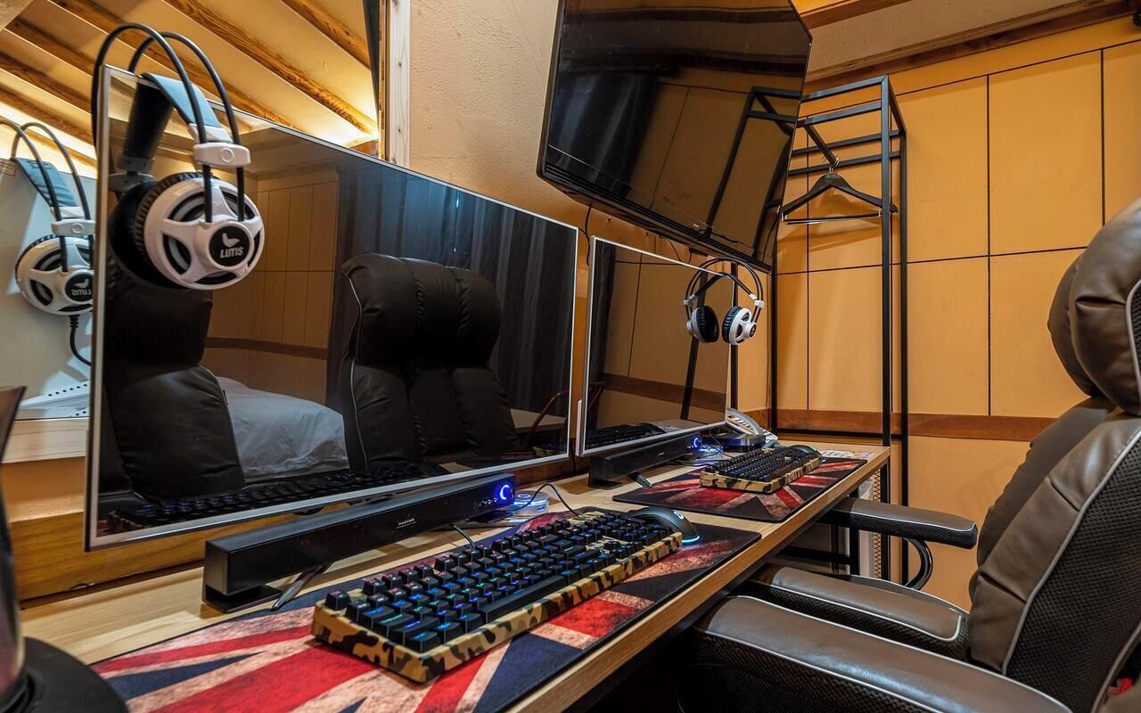 A gaming setup with multiple monitors, a mechanical keyboard, and headphones.
