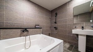 Ein modernes Badezimmer mit einer Badewanne, einer Dusche und einem Waschbecken.