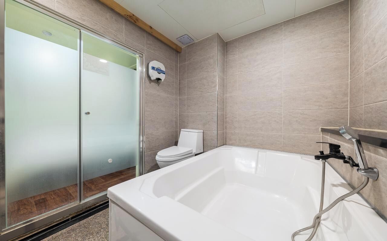 Une salle de bain avec une douche à parois de verre, une baignoire blanche et des toilettes.
