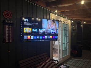 Un téléviseur à écran plat fixé au mur affiche l’interface d’un service de diffusion en continu, avec différentes options de programmes.