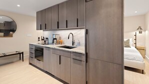 A modern kitchen with a marble countertop, built-in oven, and a large refrigerator. - Ski-In Aspen Retreat Next To Lift 1A with Fireplace & Walkable Downtown Access (Aspen)