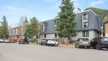 A row of modern buildings with parking spaces in front.