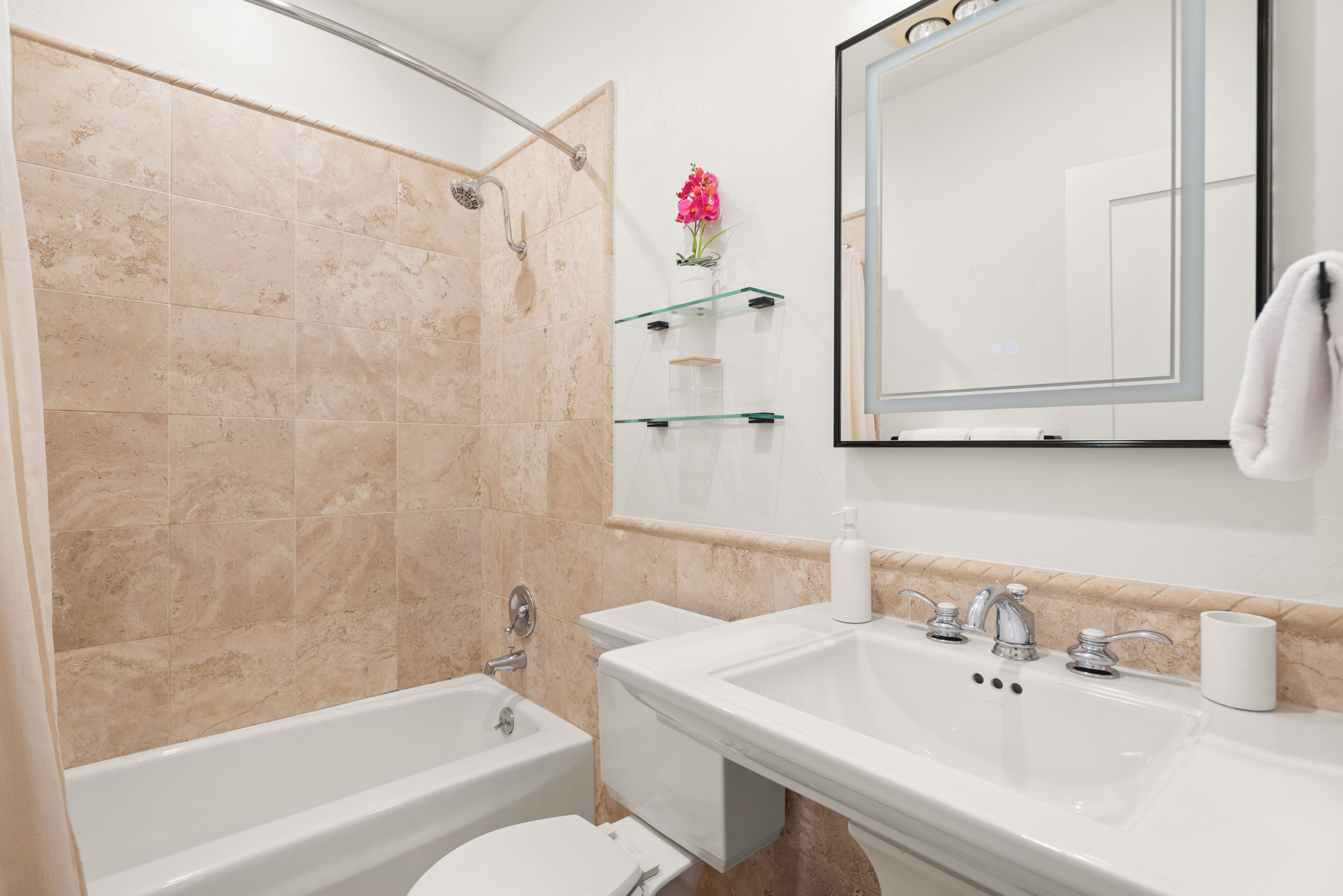 A bathroom with a bathtub, toilet, and sink.