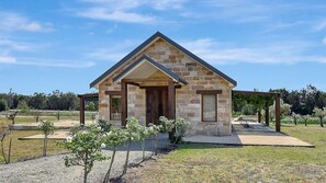 A stone house with a gabled roof, a front porch, and a small garden area. - Shiraz Vineyard Estate (Pokolbin)