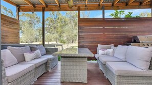 An outdoor seating area with wicker furniture and a grill. - Shiraz Vineyard Estate (Pokolbin)