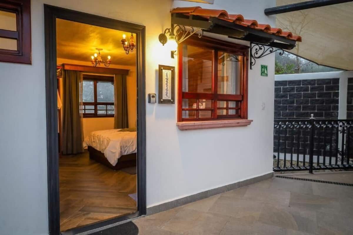 Ein Hotelzimmer mit einem Bett, einem Fenster und einer Tür, die in einen anderen Raum führt.