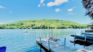 A wooden dock extending into calm water with boats docked, surrounded by lush green hills. - Direct on Lake Garfield: Book Fall Weekends! (Monterey)