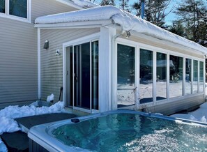 A house with a covered hot tub and a sliding glass door leading to a snowy yard. - Fall Weekends: Hot Tub, Green River Hike, Sleeps 10 (Great Barrington)