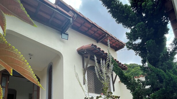 A house with a tiled roof, a small garden with steps leading to the entrance, and a window with a metal grill. - Pet-Friendly Home (Guarapari)