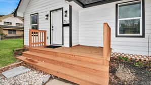 Ein eingeschossiges Haus mit Veranda, einer Tür mit der Nummer 2811 und einem kleinen Holzzaun.