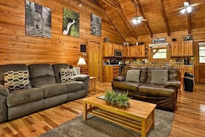 A cozy cabin interior with wooden walls, a dining area, and a kitchen.