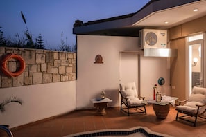 A modern outdoor patio with stone walls, a swimming pool, and outdoor furniture. - Villa Joy Mare - Private Pool Parking in Chania (Chania)