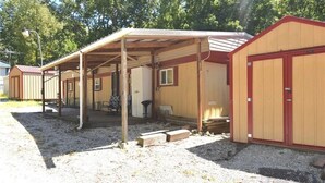 A row of wooden cabins with attached porches, each with a door and windows. - Property Rental 699 Per Week + Boat Rental 799 Per Week + Fees (Barnett)