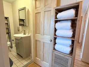 Une salle de bain équipée d’un lavabo, d’un miroir et d’un porte-serviettes en bois.