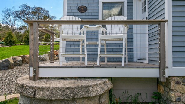 A deck with two white chairs and a stone base. - Acadia View Cottage: Peaceful, Pet Friendly, Fire Pit, Near Peaks and Echo Lake (Mount Desert)