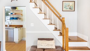A staircase with wooden railings and a cushion with text. - Acadia View Cottage: Peaceful, Pet Friendly, Fire Pit, Near Peaks and Echo Lake (Mount Desert)