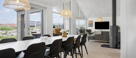 A modern interior with a dining area, seating, and a television.