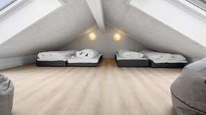 Ein Schlafzimmer im Loft-Stil mit zwei Betten, Holzboden und schrägverdeckter Decke.