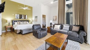 A modern hotel room with a bed, two sofas, a coffee table, and a ceiling fan. - Top Floor Luxe Condo Near Deer Valley East, Minutes to  Lake, w/ Views, Hot Tub (Heber City)