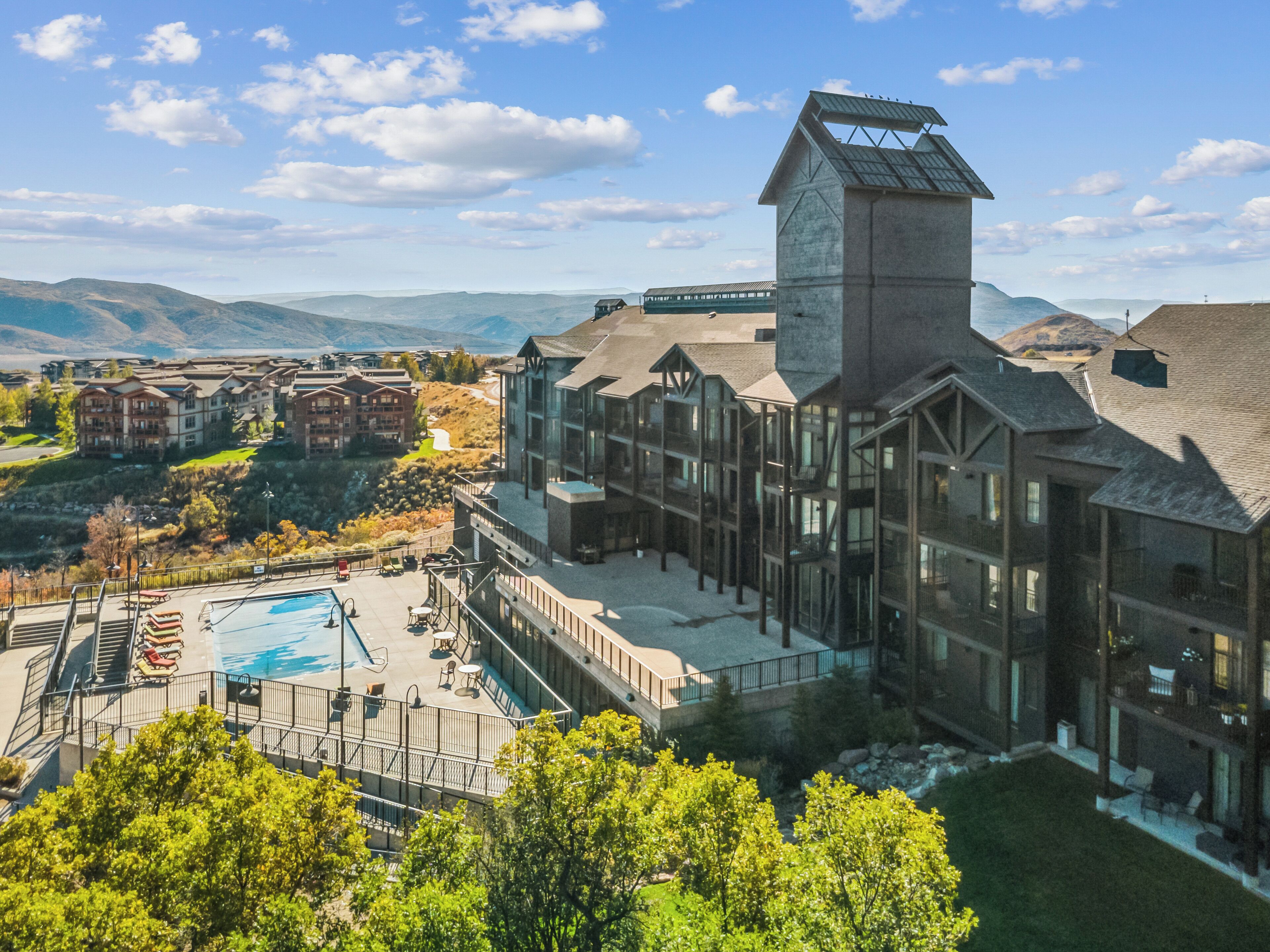 Un hôtel moderne doté d'une grande piscine, d'un télésiège et offrant une vue sur la montagne.