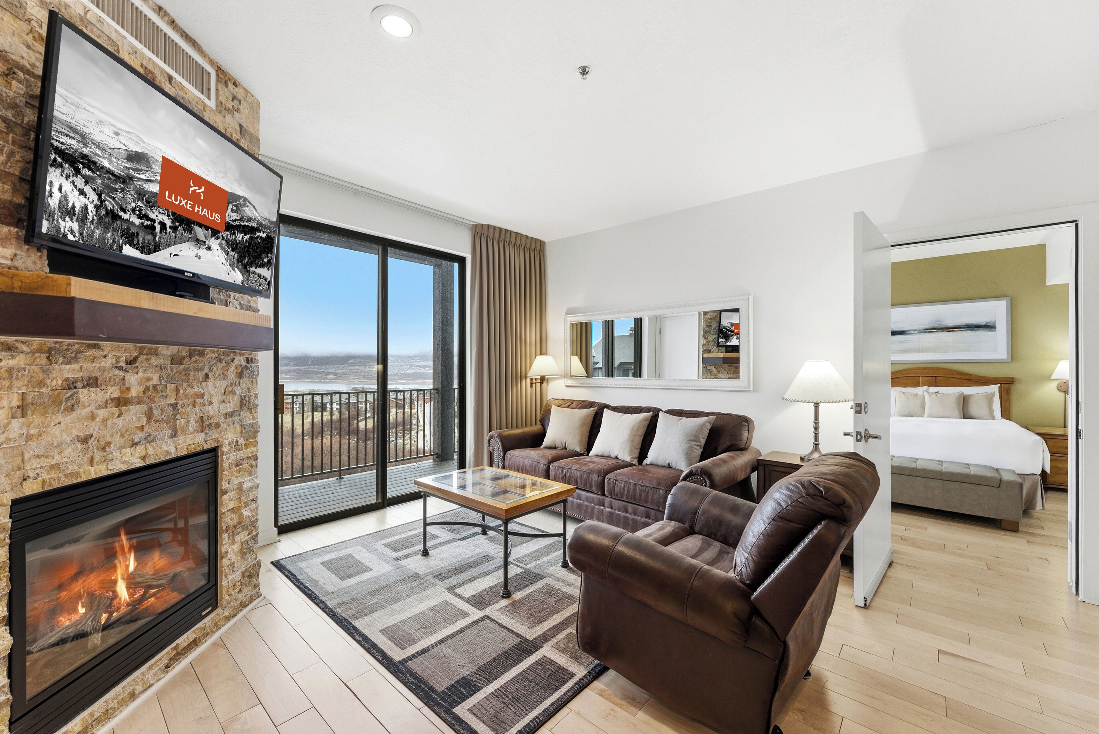 Una sala de estar moderna con chimenea, un sofá, una mesa de centro y un balcón con vistas.