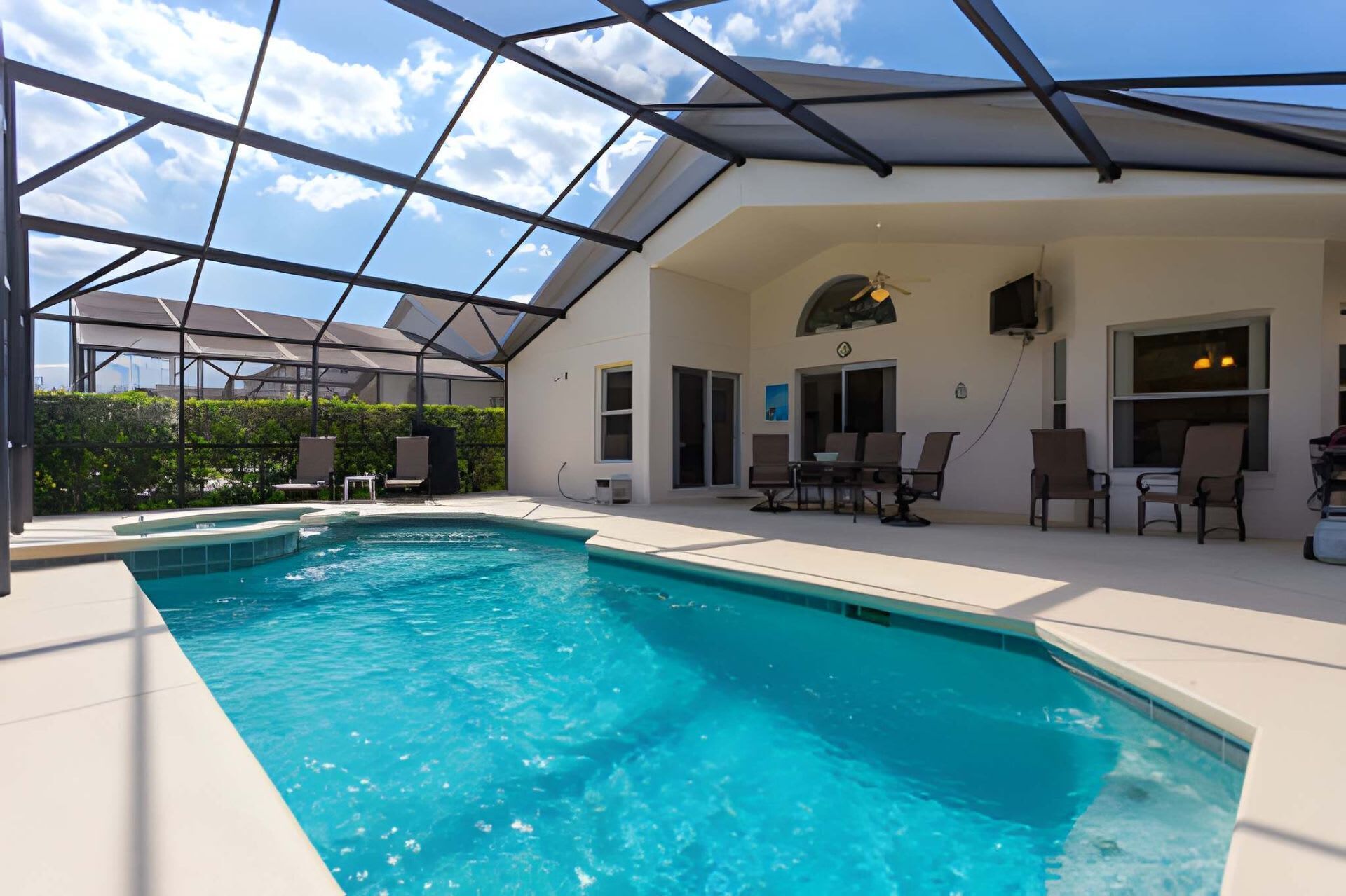 Une piscine dotée d’un toit en verre, d’un espace extérieur aménagé et offrant une vue sur le ciel.