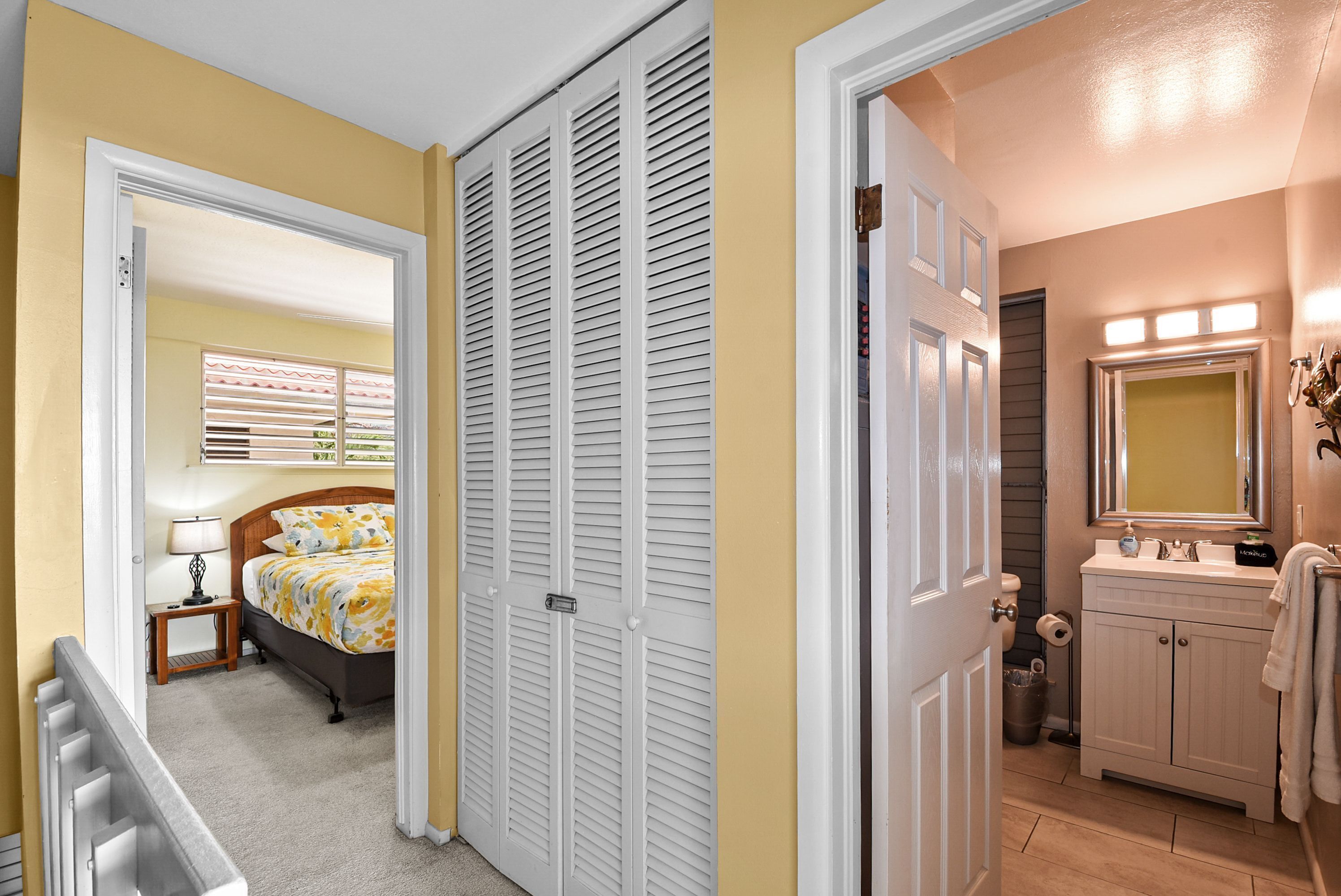 Ein Schlafzimmer mit Bett, Nachttisch und Schrank mit Klappläden.