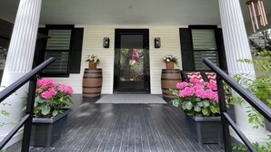 A porch with white columns, black shutters, and a black door. There are two wooden barrels with flowers on either side of the door. - King’s Gate
Fall Special • Old Town • 6 Parking • 4 King Beds (Niagara-on-the-Lake)
