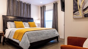 A bedroom with a bed, a nightstand, a chair, and a painting on the wall. - King’s Gate
Fall Special • Old Town • 6 Parking • 4 King Beds (Niagara-on-the-Lake)