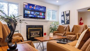 A modern living room with a fireplace, comfortable seating, a flat-screen TV, and a Canadian flag. - King’s Gate
Fall Special • Old Town • 6 Parking • 4 King Beds (Niagara-on-the-Lake)