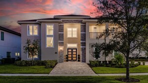 A modern two-story house with a stone facade, large windows, and a well-maintained front yard. - 5 Star Villa Aurelius – A Golden Grand Residence (Orlando)
