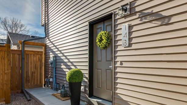 A house with a front door, a mailbox, and a wooden fence. - Private Calgary Suite | Full Kitchen, Laundry, Workspace & Free Parking (Calgary)