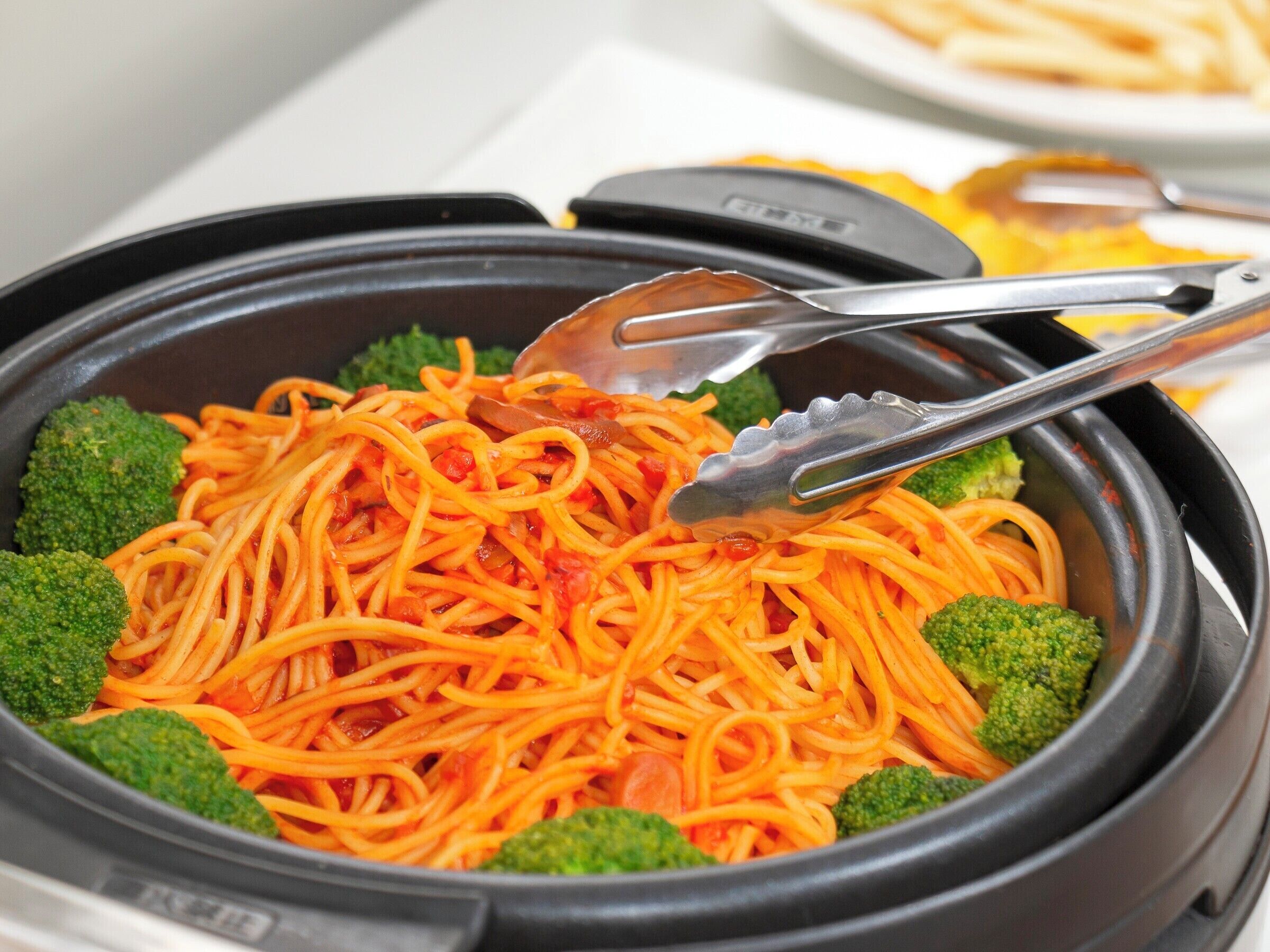 A bowl of spaghetti with broccoli and carrots.