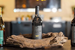 A bottle of Featherstone Ranch Tannat wine on a wooden surface with a blurred background.
