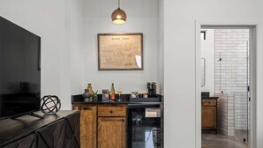 Eine moderne Küche mit schwarzem Arbeitsplatz, Holzschränken, einem Geschirrspüler und einer Karte des Gillespie County an der Wand.