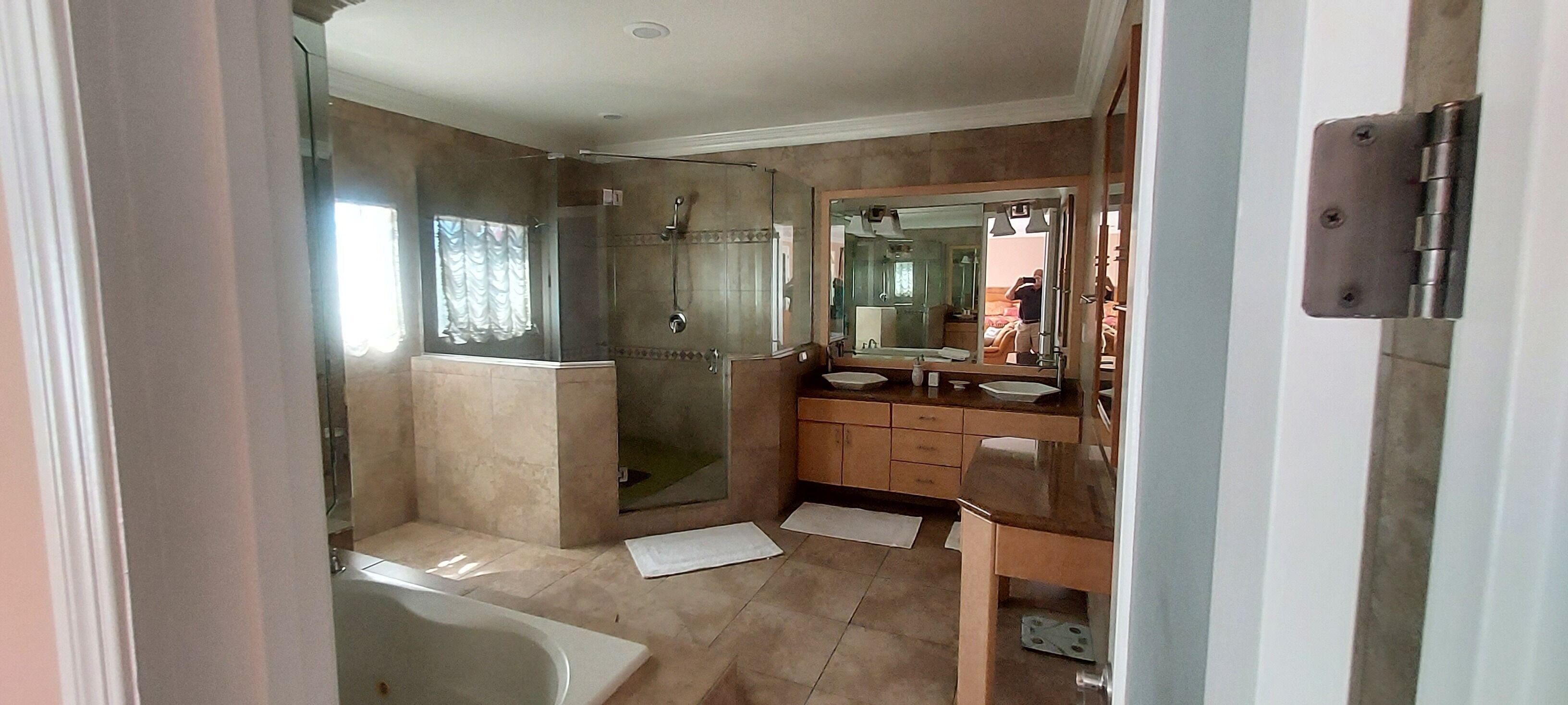 A bathroom with a walk-in shower, a bathtub, and a vanity with a mirror.