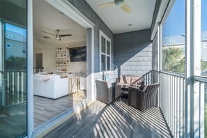 Ein modernes Wohnzimmer mit einem weißen Sofa, einem Esstisch und Korbstühlen.
