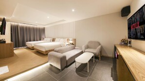 A modern hotel room with a large bed, two smaller beds, a sofa, a desk, and a TV wall. - Gimhae The Van Hotel (Gimhae)
