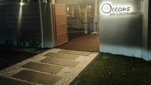 A bar and restaurant named 'Oceans' with a wooden deck and a gravel pathway leading to the entrance. - Saltwater Sand - relax by the beach (East Mackay)