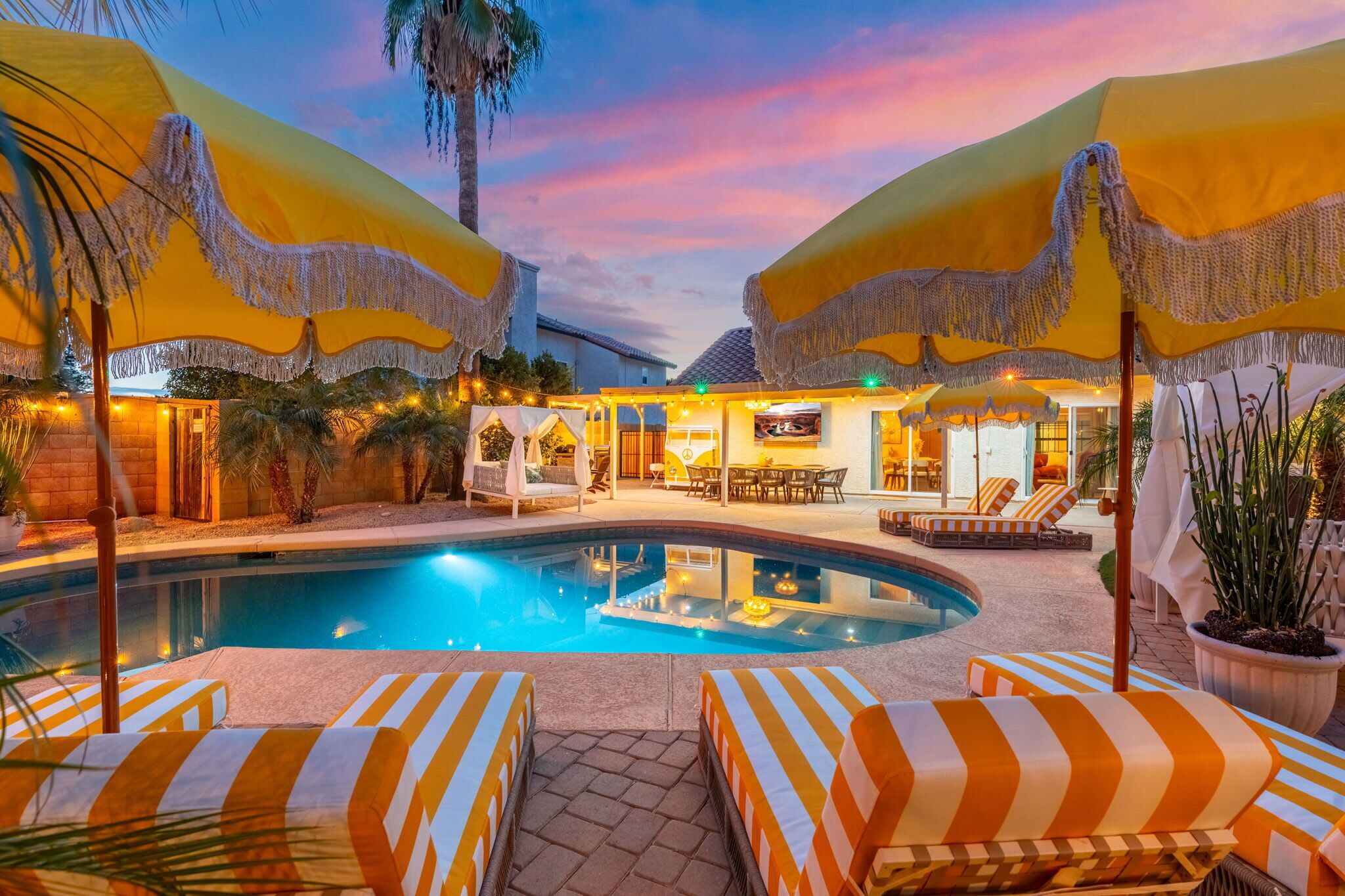 Un espace aménagé au bord de la piscine, avec des parasols jaunes, des chaises longues et une piscine.