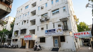 A multi-story building with signs for 'HOTEL SONEVA' and 'HOTEL SONEVA AC | Non AC Room'. - Soneva Hotel (Ahmedabad)