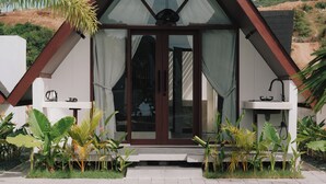 A modern house with a triangular roof, large glass doors, and a pool in the foreground. - Limbo Lux Bungalows (Kuta)