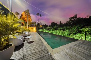 Ein modernes Haus mit Pool, umgeben von üppigem Grün.