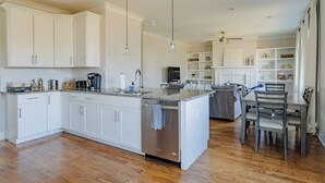 A spacious kitchen with white cabinets, a central island, and a dining area with a table and chairs. - 4BR Nashville Stay w/ Pool Table & Patio! (Nashville)