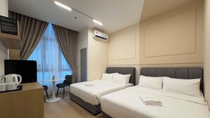 A hotel room with two beds, a desk with a coffee maker, a chair, and a view of the outside. - The Suite by Manhattan Group (Kuala Lumpur)