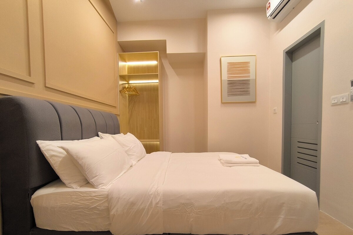 Ein Bett mit Kopfteil, ein Nachttisch und eine Wand-Klimaanlage.