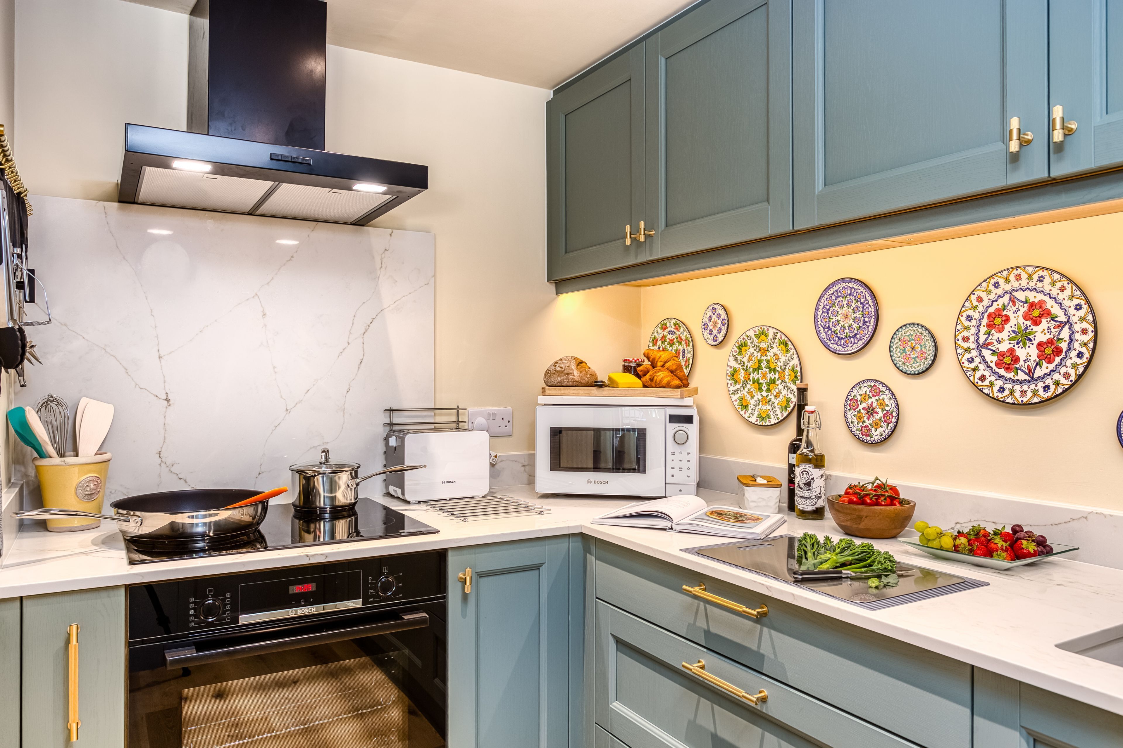 A modern kitchen with a stove, microwave, and various utensils.