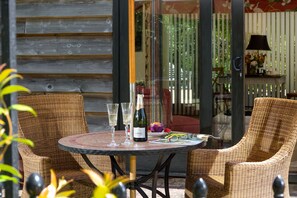 A wicker chair and table set with a bottle of wine, glasses, and a menu. - Harts Leap -  Redmarley D'Abitot , Gloucestershire (Redmarley D'Abitot)