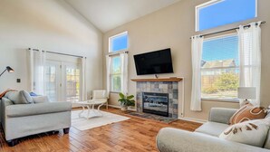 Ein Wohnzimmer mit Kamin, Flachbildfernseher und Sofa.